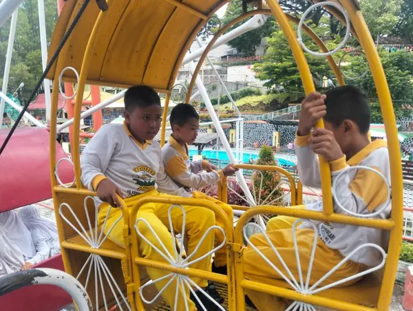 Foto aksi dokumentasi Flying Fox rombongan siswa dengan latar pepohonan asri